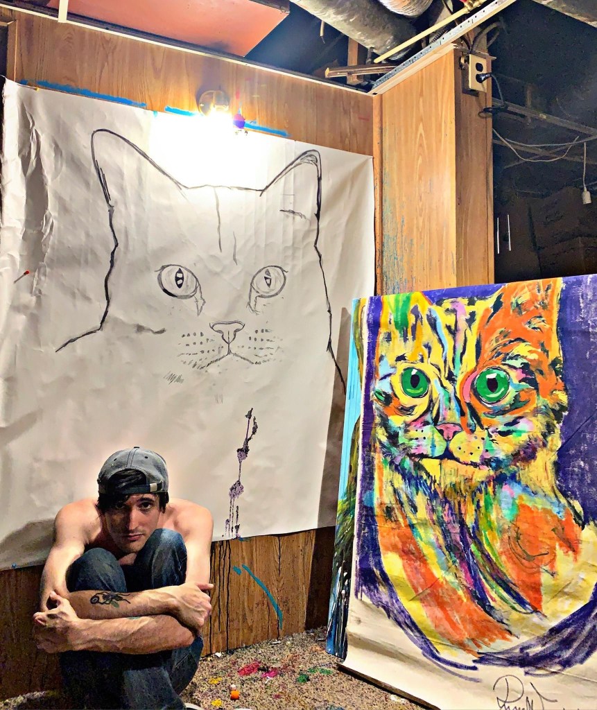 Artist Russell Frantom in his studio with his cat paintings 
