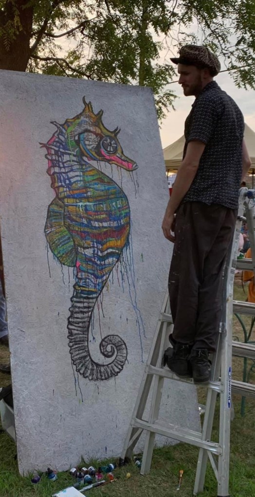Artist Russell frantom paints a seahorse at an event in 2019 