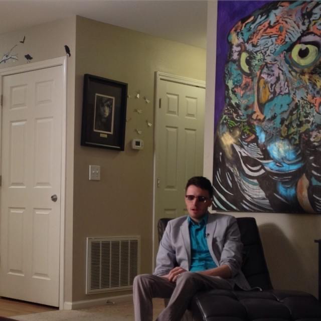 Artist Russell frantom sits for a news interview near one of his owl paintings (sold) 2014 ​