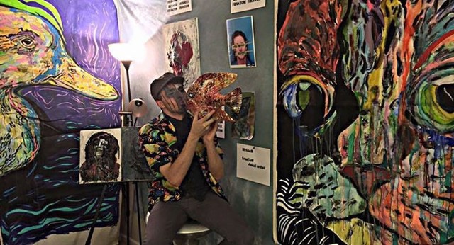 Artist Russell frantom at art show with paintings 
