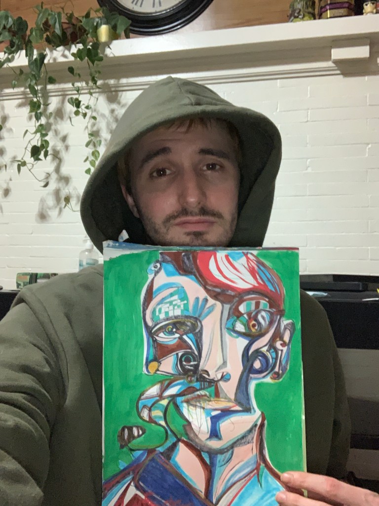 Artist Russell Frantom holds up one of his abstract green portrait paintings 2022 mixed media 