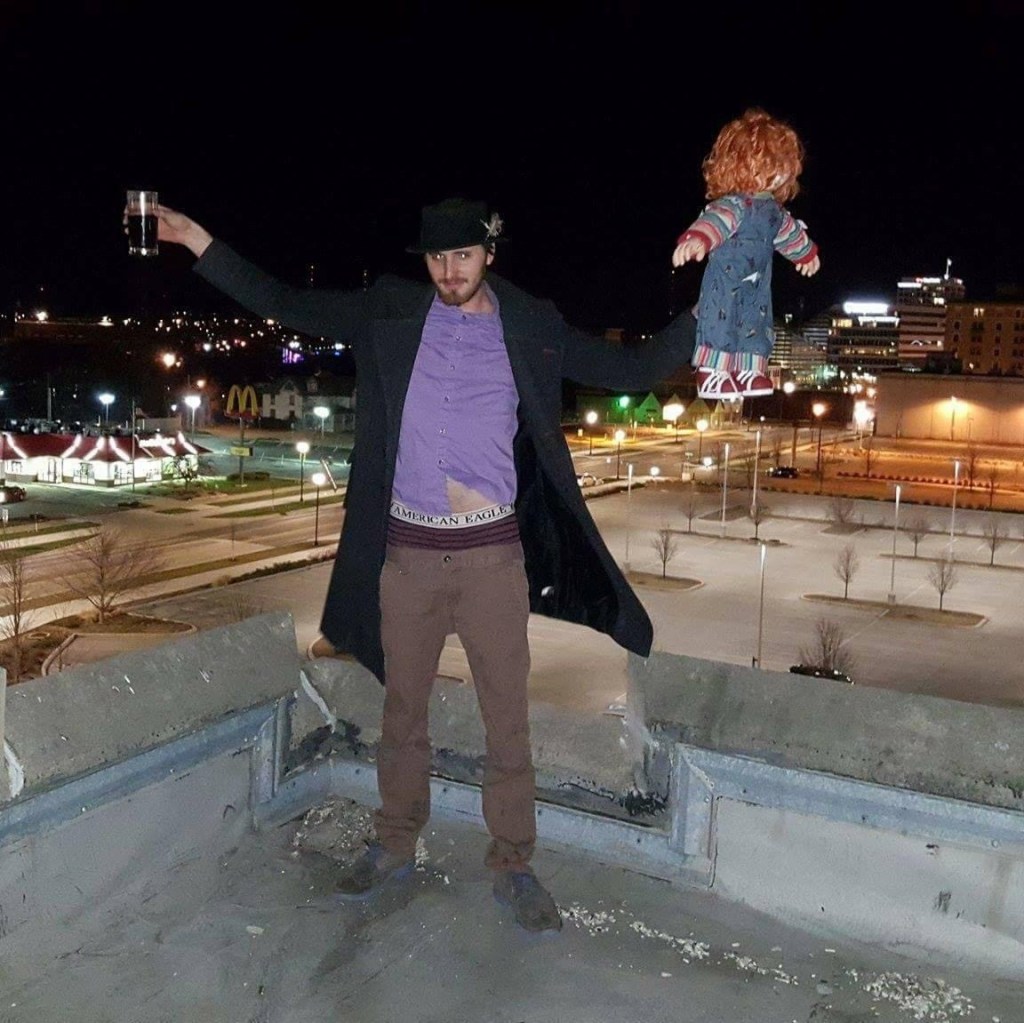 Russell Frantom with chucky doll on rooftop 