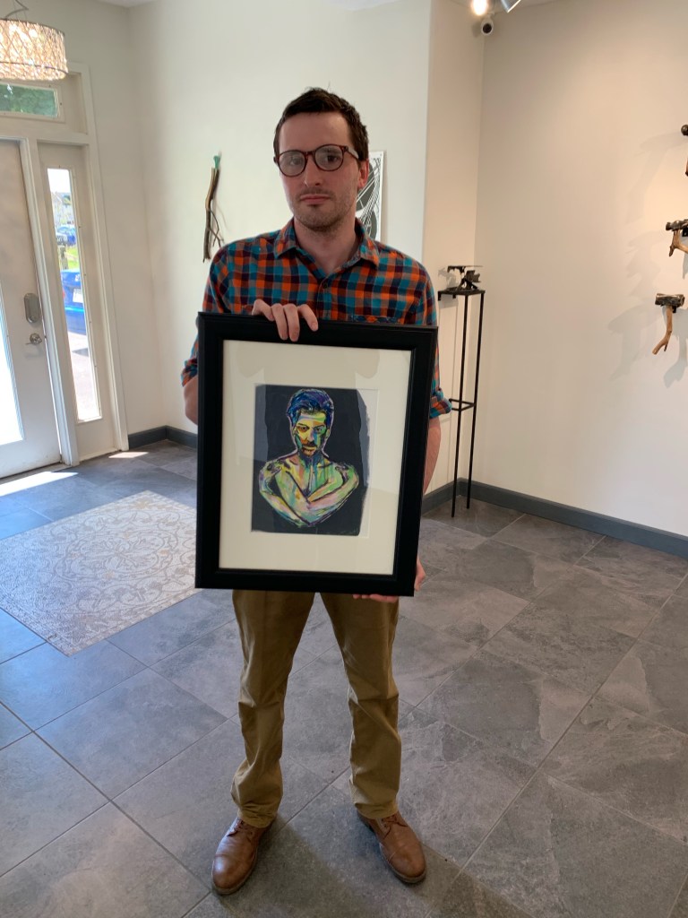 Artist Russell Frantom holds one of his paintings in an art gallery in Chicago. 2018